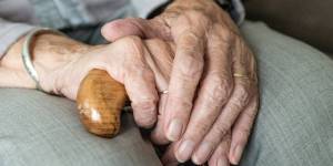 elderly persons hands folded in lap