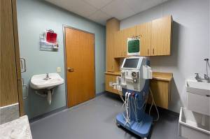 private exam room with cabinets and dialysis machine