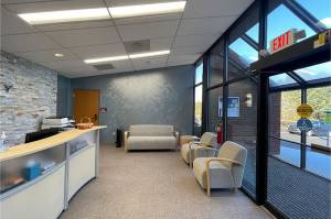 waiting room and welcome desk with view of glass enclosed entrance